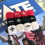 Douze dés Fate colorés pour vos sessions de jeu de rôle